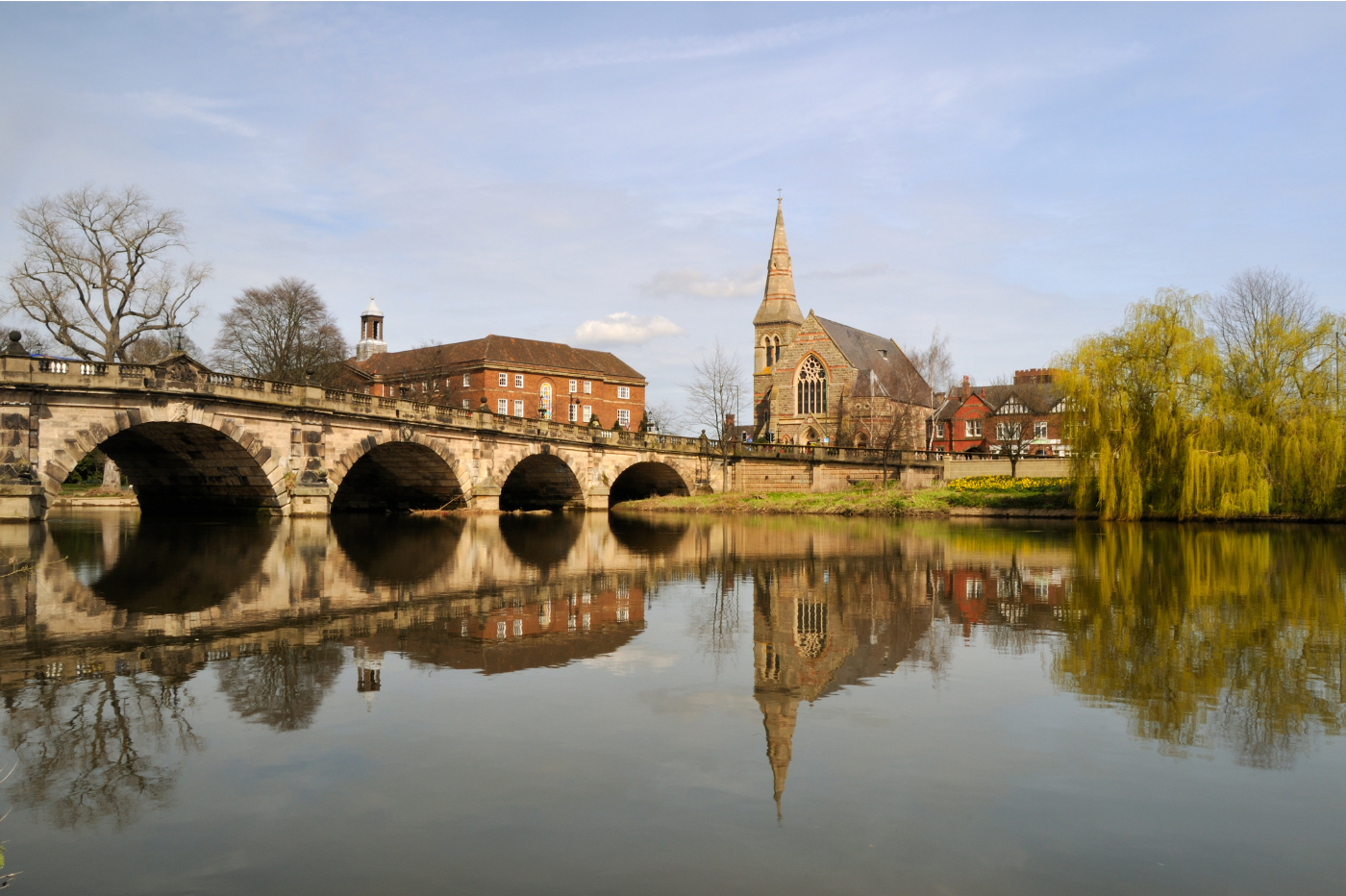 Shrewsbury English Bridge and Abbey reflected in calm water with clear sky